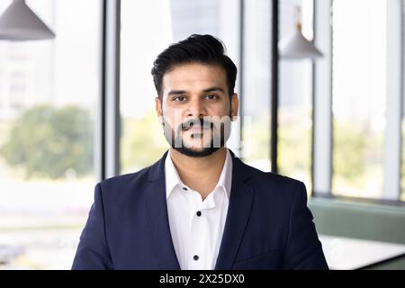 Ernsthaft gutaussehender junger indischer Profi-Mann, der in die Kamera schaut Stockfoto