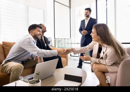 Fröhliche Geschäftskollegen schütteln bei diversen Geschäftsteams die Hand Stockfoto