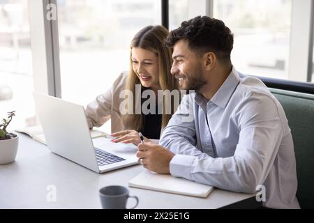 Zwei Kollegen arbeiten an einem Projekt am Laptop im Coworking Café Stockfoto