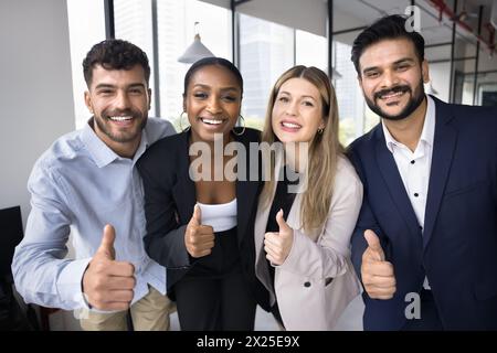 Glückliches erfolgreiches Team, das sich im Büro für ein Porträt ausgibt Stockfoto