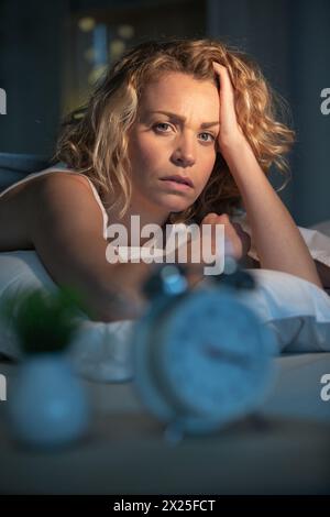 Frau, die im Bett aufwacht und an Schlaflosigkeit leidet Stockfoto