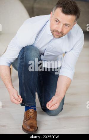 Bräutigam befestigen die Schnürsenkel an stilvollen braunen Lederschuhen Stockfoto