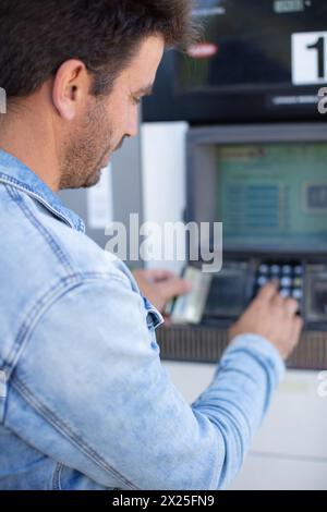 Mann, der Geld vom geldautomaten nimmt Stockfoto