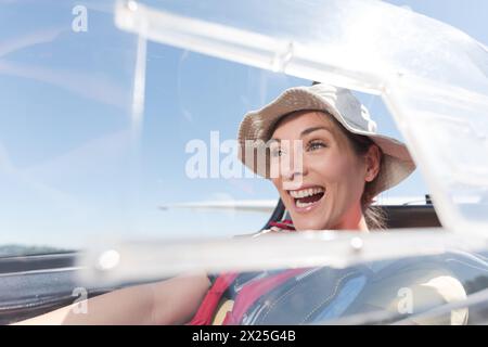 Lächelnde Pilotin im Cockpit des leichten Flugzeugs Stockfoto