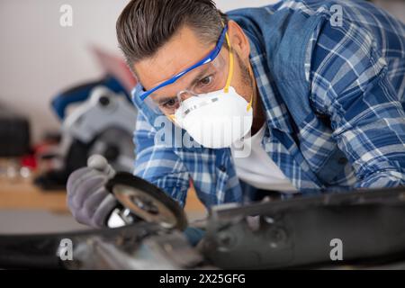 Junge Karosseriebauer bei der Arbeit mit Schutzausrüstung Stockfoto