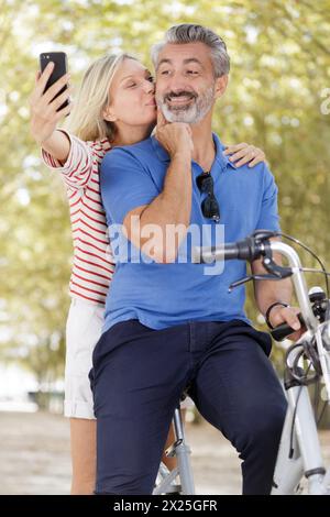 Ein reifes Paar, das ein Selfie auf dem Fahrrad macht Stockfoto