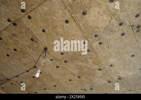 Dämmplatten aus Mineralwolle, die an der Decke verklebt wurden. Stockfoto