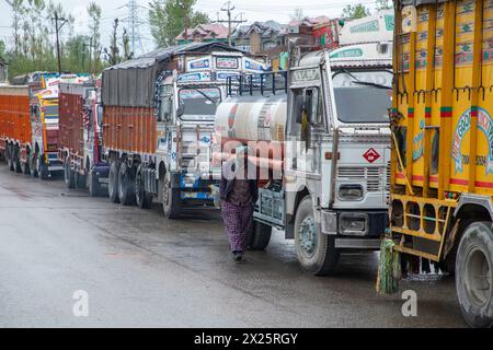 Ramban, Indien. April 2024. Ein Fahrer läuft in der Nähe von Lastkraftwagen, die Güter transportieren, und das wesentliche bleibt an einer Straße in Qazingund, einem Viertel im Bezirk Anantnag, hängen. Die Verkehrsbewegung auf der Hauptstraße Kaschmirs blieb aufgrund der jüngsten Erdrutsche, die durch frische Regenfälle ausgelöst wurden, stehen. Die Himalaya-Region in Kaschmir wurde Zeuge von Regenfällen aus den vergangenen Tagen, die die Verkehrsbewegung stoppten und das normale Leben beeinträchtigten. (Foto: Faisal Bashir/SOPA Images/SIPA USA) Credit: SIPA USA/Alamy Live News Stockfoto