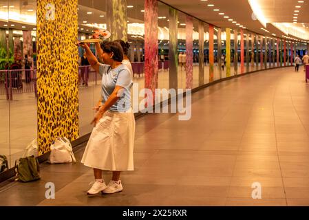 Zwei Frauen mittleren Alters üben ihre Tanzführung gemeinsam vor großen Spiegeln in einer unterirdischen MRT-Station in Singapur Stockfoto