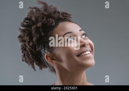 Das fröhliche Aussehen der Frau wird erfasst, während sie nach oben blickt, und die Augen funkeln vor Freude Stockfoto