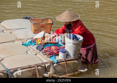 MUANG NGOI NEUA, LAOS - 25. NOVEMBER 2019: Einheimische Frau, die im Fluss Nam ou im Dorf Muang Ngoi Neua, Laos, Wäsche macht Stockfoto