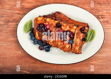 Barbecue Schweinerippchen mit Blaubeersauce auf einem alten Holztisch Stockfoto