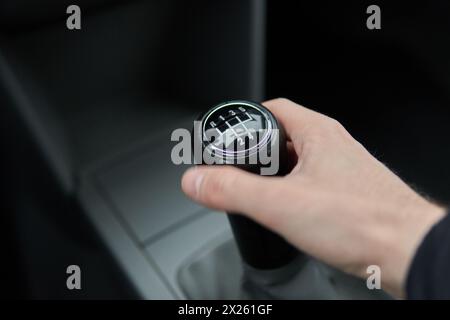 Man hält Schaltknauf Handschaltgetriebe, Griff Schaltgriff im Fahrzeuginnenraum Stockfoto