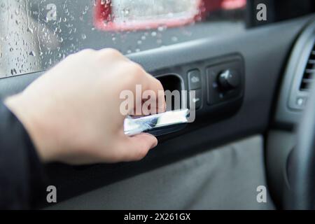 Die Hand des Beifahrers hält den Türgriff von innen Stockfoto