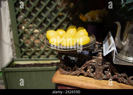 Künstliche Zitronen auf Vintage-Waage. Dekorationskonzept Stockfoto