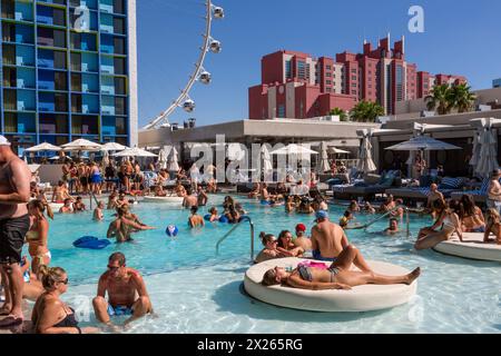 Las Vegas, Nevada. Millennials entspannen am Pool, dem Linq Hotel. High Roller, das weltweit höchste Beobachtungsrad (Stand 2015) im Hinterland Stockfoto