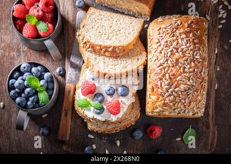 Gesundes und hausgemachtes Vollkornbrot mit Himbeeren und Heidelbeeren. Brot als frisches Mittagessen mit Beeren. Stockfoto