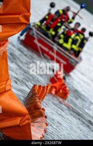 Schweinfurt, Deutschland. April 2024. Eine Ölbarriere wird auf das Wasser gezogen. Die Feuerwehren der Stadt und des Landkreises Schweinfurt und die Wasserrettungseinheiten am Main üben im Katastrophenfall aus. Es wird davon ausgegangen, dass Öl auf fließendes Wasser austritt. Quelle: Pia Bayer/dpa/Alamy Live News Stockfoto