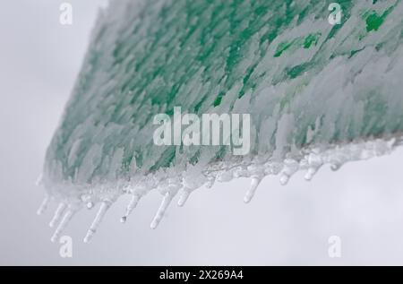 Schierke, Deutschland. April 2024. Eiszapfen bilden sich auf einem Wegweiser am Brocken. Eine kalte Wetterfront brachte viel Schnee in die höheren Höhen des Harzes. Am Samstag können Besucher des Brocken eine winterliche Landschaft genießen. Quelle: Matthias Bein/dpa/Alamy Live News Stockfoto