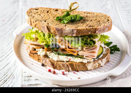Sandwich auf dunklem Brot mit Schinken, Gurke und Frischkäse. Hochwertige Fotos Stockfoto