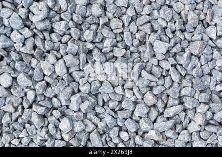 Nahaufnahme eines strukturierten. Grober Schotterhintergrund. Ein haltbares Baumaterial. Aus Grau. Zerquetschter Stein. Perfekt für Bau- und Landschaftsgestaltung Stockfoto