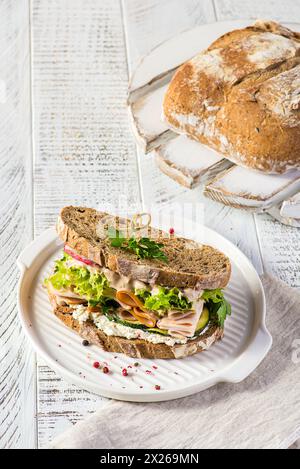 Sandwich auf Brot mit Schinken, Gurke und Frischkäse Stockfoto