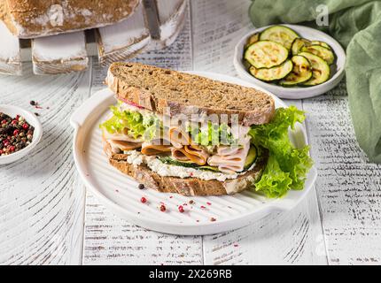 Sandwich auf Brot mit Schinken, Gurke und Frischkäse Stockfoto