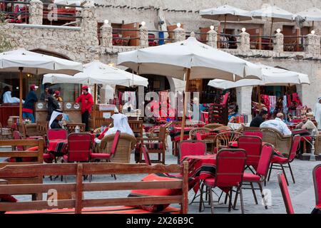 Doha, Katar. Ein Café im Freien in der Nähe des traditionellen Marktes. Arabische Männer rauchen Wasserpfeifen (Shisha, Nargileh, Sheesha). Stockfoto