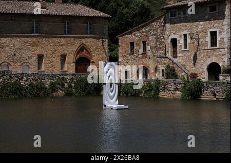 Moderne Kunstwerke über dem Wasser des Katharinenbades aus dem 16. Jahrhundert, einem rechteckigen Pool in Bagno Vignoni in der Toskana, Italien, gefüllt mit heißem vulkanischem Quellwasser, das aus der Tiefe des Untergrunds sprudelt. Das wohltuende und heilende Wasser von Bagno Vignoni hat Etrusker, Römer, die hl. Katharina von Siena, Papst Pius II. Und Lorenzo den herrlichen angezogen. Der Pool war auch der Hauptort für Andrej Tarkovskys Film Nostalghia aus dem Jahr 1983. Stockfoto