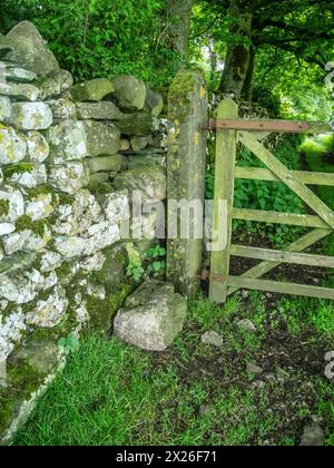 Nicht jeder auf dem Land ist freundlich, denn dieses Bild zeigt ein mit einem Vorhängeschloss gesichertes Tor auf einem öffentlichen Fußweg oder den angrenzenden Torspaltsteig, der von Felsen blockiert wird. Ihre einzige Möglichkeit ist, über das Tor zu klettern Stockfoto