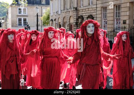 Bath, UK. April 2024. Die Extinction Rebellion veranstaltet heute eine Beerdigung für die Natur im Zentrum von Bath. Die Rebellen der Rebellen, begleitet von Trommlern, die einen Begräbnisschlag spielten, bahnten ihren Weg durch die Stadt, um die Notlage der Umwelt hervorzuheben. Mit etwa 400 Jahren ist dies die größte Versammlung der Roten Rebellen aller Zeiten. Die Gruppe schärft das Bewusstsein für den Status des Vereinigten Königreichs als eines der am stärksten von der Natur betroffenen Länder der Welt. Quelle: JMF News/Alamy Live News Stockfoto