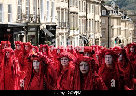 Bath, UK. April 2024. Die Extinction Rebellion veranstaltet heute eine Beerdigung für die Natur im Zentrum von Bath. Die Rebellen der Rebellen, begleitet von Trommlern, die einen Begräbnisschlag spielten, bahnten ihren Weg durch die Stadt, um die Notlage der Umwelt hervorzuheben. Mit etwa 400 Jahren ist dies die größte Versammlung der Roten Rebellen aller Zeiten. Die Gruppe schärft das Bewusstsein für den Status des Vereinigten Königreichs als eines der am stärksten von der Natur betroffenen Länder der Welt. Quelle: JMF News/Alamy Live News Stockfoto