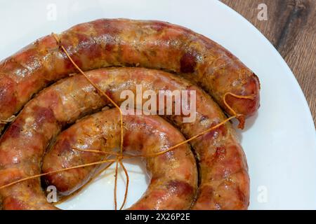 Gebackene Wurst. Hausgemachte Schweinswurst. Hausgemachte Wurst auf dem Teller. Nahaufnahme Stockfoto