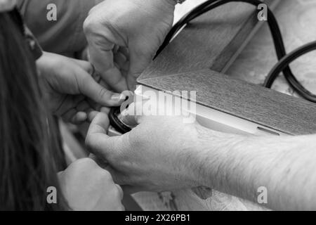 Hände, die Gummistreifen auftragen. Konzeptverbesserung der Abdichtung, Schalldämmung, Wärmedämmung von Fenstern und Türen. Professionelle Versiegelung eines Fensters Stockfoto