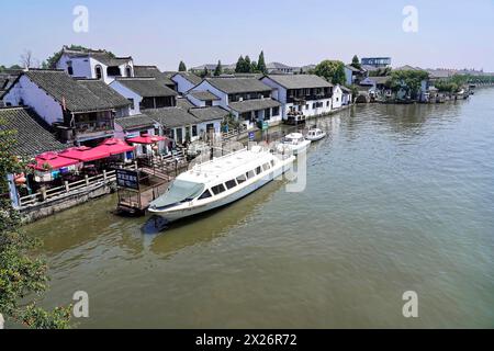 Ausflug zum Wasserdorf Zhujiajiao, Shanghai, China, Asien, Holzboot auf dem Kanal mit Blick auf historische Architektur, moderne Wasserfahrzeuge und Stockfoto