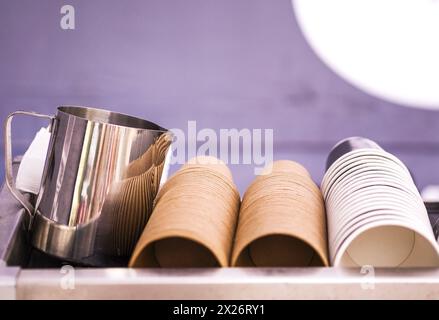 Die Ränge der Papierkurben. Kaffeetassen, Gläser. Wand aus Tassen aus Pappe. Kunststoffbecher, Deckel, Strohhalme, Röhrchen Stockfoto