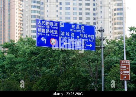 Shanghai, Volksrepublik China, Verkehrsschilder vor einem Baumhintergrund zeigen verschiedene Straßennamen, Shanghai, China Stockfoto