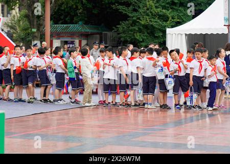 Eine Gruppe von Schulkindern in Uniformen mit roten Tüchern steht in Ordnung auf einem Sportplatz in Chongqing, Chongqing, Provinz Chongqing, China Stockfoto