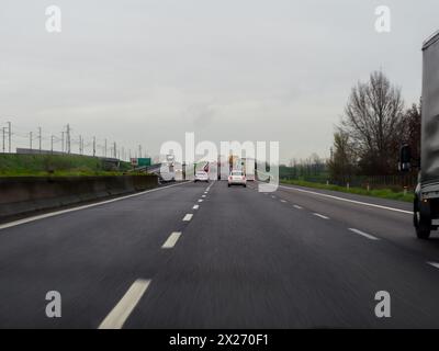 Mailand, Italien - 26. April 2023 nach einem Auto auf einer Autobahn bei bewölktem Wetter, Autobahn A1 A8 in der Nähe von Mailand, Italien Stockfoto
