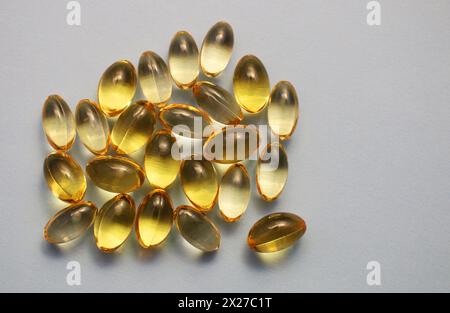 Transparente gelbe Fischöl-Kapseln in Draufsicht...pharmazeutisches Konzept. Stockfoto