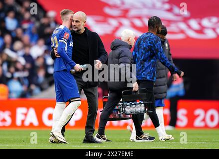 Manchester City-Manager PEP Guardiola schließt sich Chelsea Cole Palmer (links) nach dem Halbfinalspiel des Emirates FA Cup im Londoner Wembley Stadium an. Bilddatum: Samstag, 20. April 2024. Stockfoto