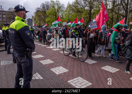 Den Haag, Südholland, Niederlande. April 2024. Die niederländische Polizei wacht, während pro-palästinensische Demonstranten vorbeiziehen. Am 20. April 2024 marschierten pro-palästinensische Demonstranten in Solidarität mit Gaza durch das Zentrum von den Haag in den Niederlanden. (Kreditbild: © James Petermeier/ZUMA Press Wire) NUR REDAKTIONELLE VERWENDUNG! Nicht für kommerzielle ZWECKE! Quelle: ZUMA Press, Inc./Alamy Live News Stockfoto