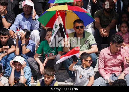 Mossul, Irak. April 2024. Iraker bedecken sich während der Aktivitäten des Frühlingsfestes im Festbereich in der Stadt Mossul im Nordirak mit einem Regenschirm. Das Festival findet zum zweiten Mal in Folge statt, seit es nach 2003 wegen der US-Invasion auf den Irak zwei Jahrzehnte lang aufhörte. Die Frühlingsfeste gehen auf die Ära der Assyrer zurück, die die Frühlingssaison und den Beginn des assyrischen Jahres Akitu feierten. Der Beginn dieses Festivals in Mossul war 1969 n. Chr. (Foto: Ismael Adnan/SOPA Images/SIPA USA) Credit: SIPA USA/Alamy Live News Stockfoto