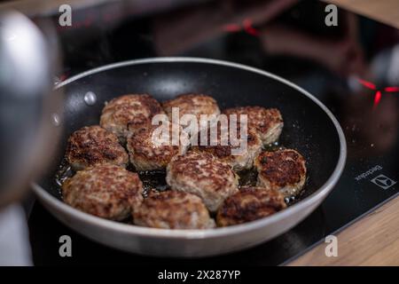 Goldbraune Fleischbällchen, perfekt gebraten, in einer Pfanne über einem Herd, mit Reflexen eines Hauskochs in Aktion. Hochwertige Fotos Stockfoto