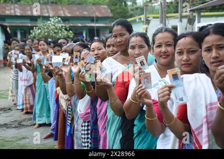 Disangmukh, Indien. April 2024. Indische Wähler halten ihre Personalausweise hoch, während sie in der Schlange warten, um ihre Stimme in der ersten Phase der allgemeinen Wahlen abzugeben, am 19. April 2024 in Disangmukh, Sivasagar, Assam, Indien. Fast 969 Millionen Menschen können in der weltweit größten Demokratie wählen, wobei in den nächsten sechs Wochen sieben Wahlphasen stattfinden. Quelle: PIB Photo/Press Information Bureau/Alamy Live News Stockfoto