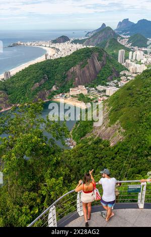 Ein junges Paar Blick auf Rio de Janeiro vom Sugarloaf Mountain, Rio de Janeiro, Bundesstaat Rio de Janeiro, Brasilien. Stockfoto