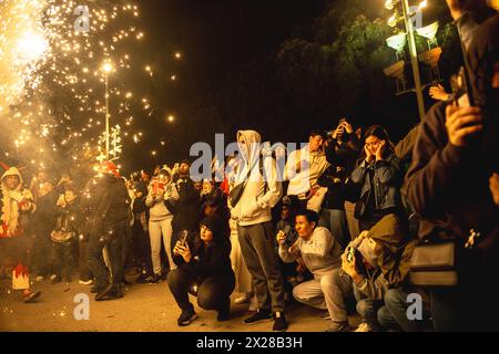 Barcelona, Spanien. April 2024. Touristen fotografieren mit ihren Handys die 'Correfocs' bei der 'Festa Major de la Sagrada Familia'. Quelle: Matthias Oesterle/Alamy Live News Stockfoto