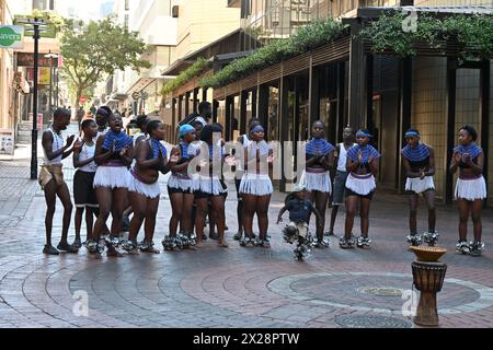 Gruppe von schwarzen Jungen und Mädchen in lokalen Kostümen, die einen typischen afrikanischen Tanz im Stadtzentrum von Kapstadt, Südafrika, aufführen Stockfoto