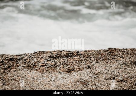 Kleine Meereswelle, verschwommen Weiche schaumige Wellen waschen goldenen Sandstrand bei Sonnenuntergang. Meereswellen Am Sandstrand. Niemand. Urlaubskonzept Stockfoto