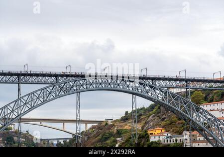 Frontalansicht vom Fluss der Don Luis I Stahlbrücke mit Menschen, die gehen, Fotos machen und posieren, und drei anderen Brücken im Hintergrund Stockfoto